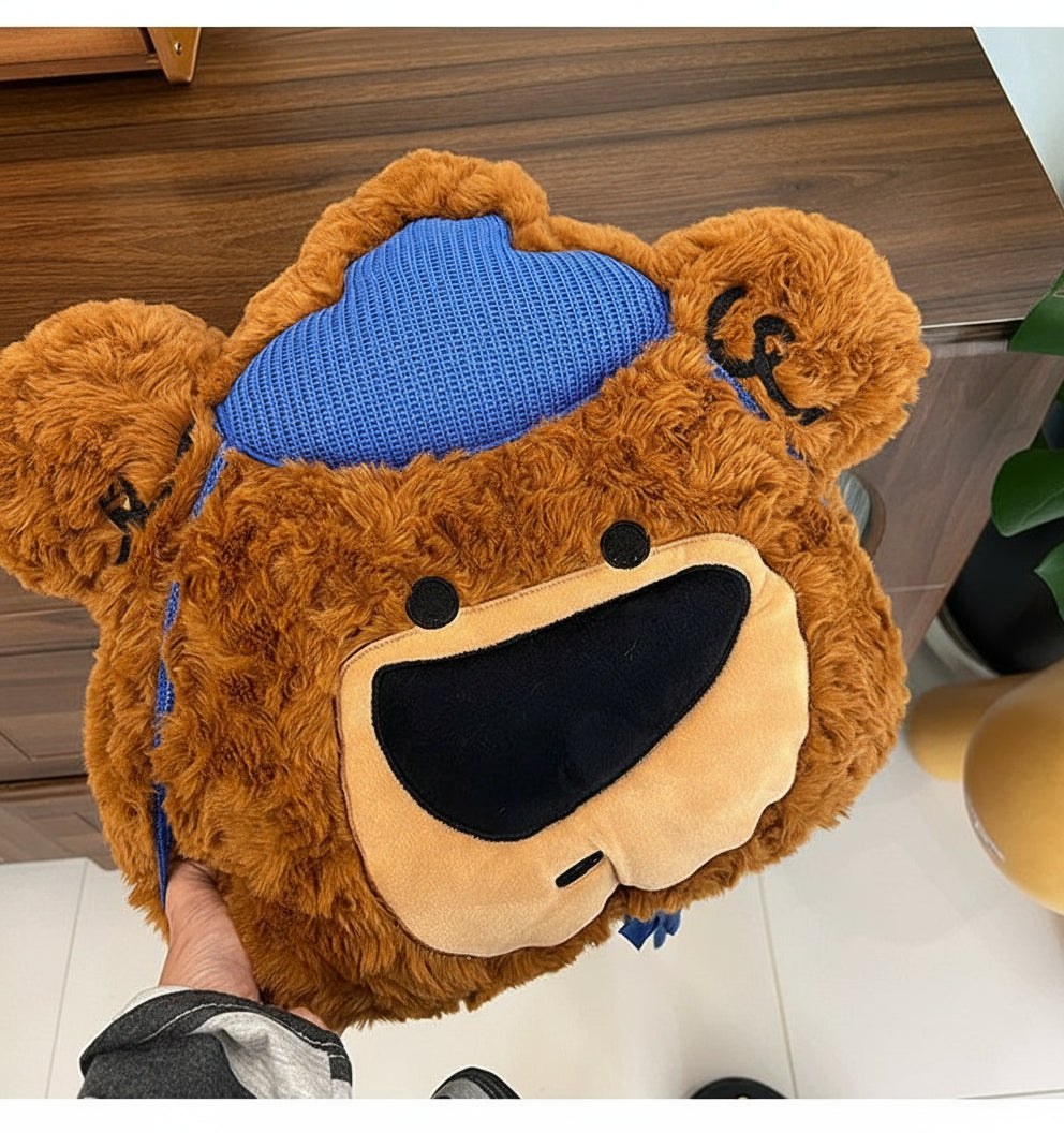 Plush toy bear with a blue hat on a wooden floor