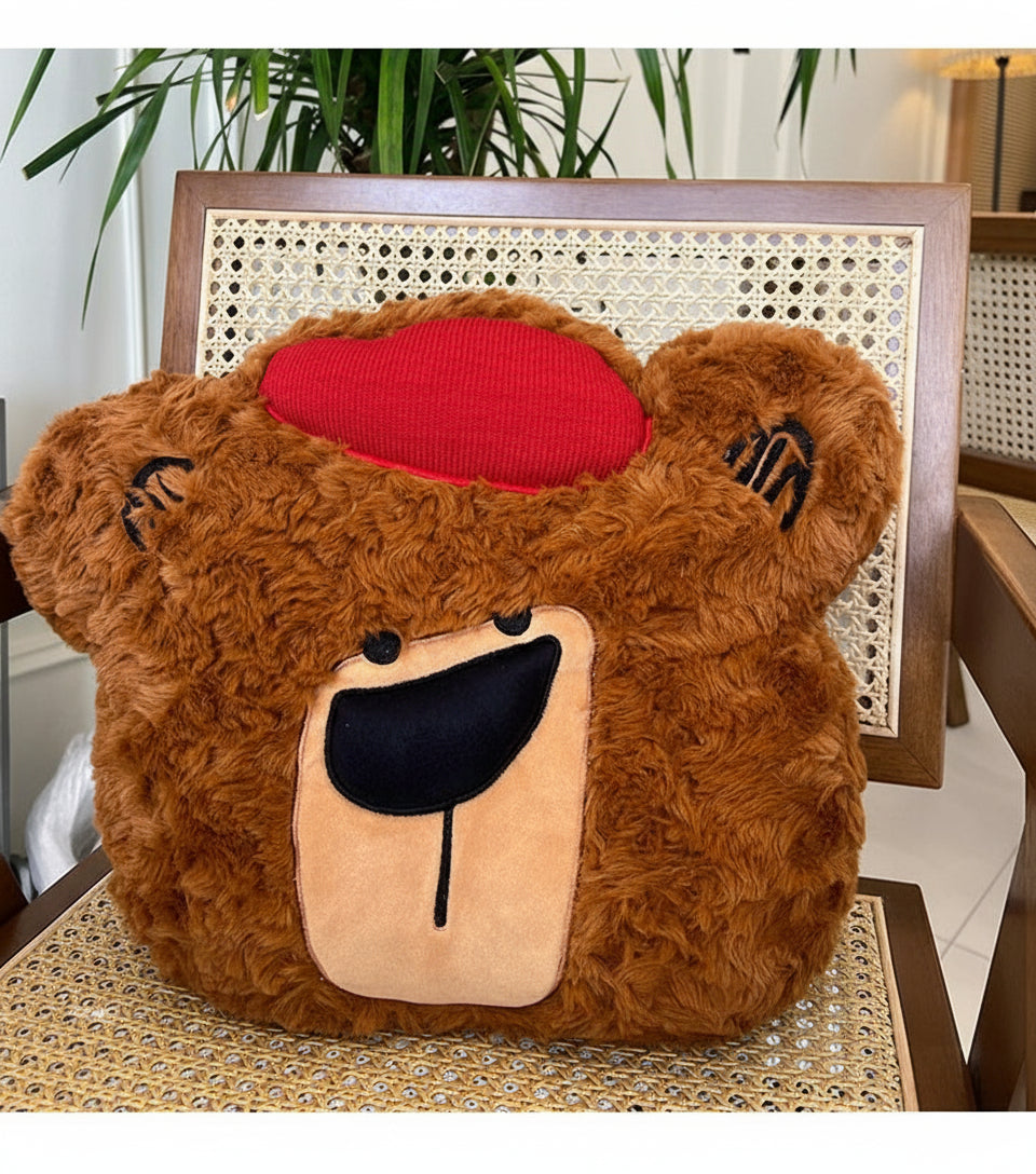 Plush bear pillow with a red heart on a chair