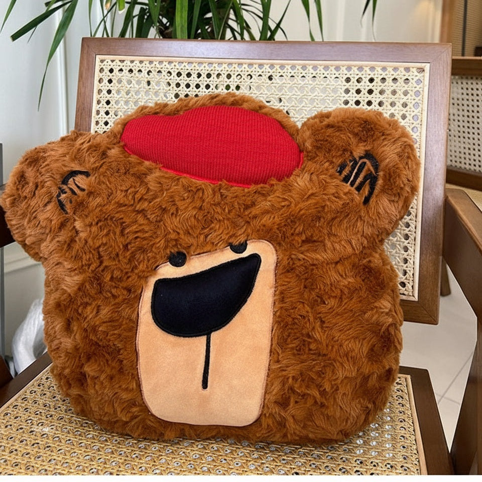 Plush bear pillow with a red heart on a chair