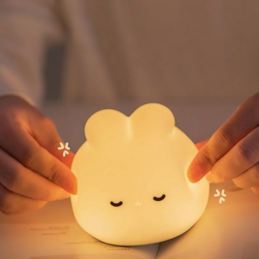 Cute animal-shaped night light held by hands with a warm glow.