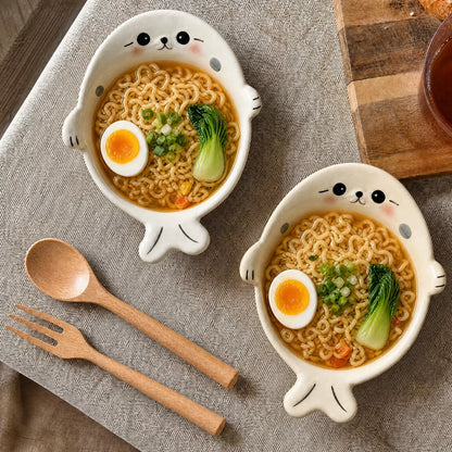 White and cream seal-shaped bowls filled with noodles
