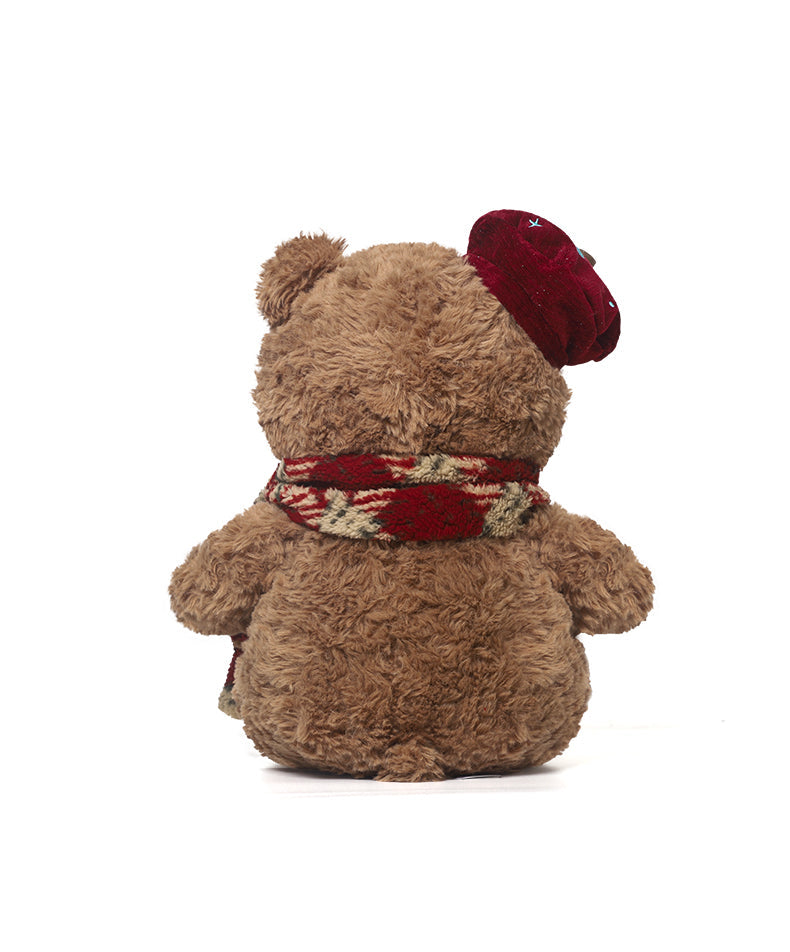 Brown teddy bear with a red hat and scarf on a white background