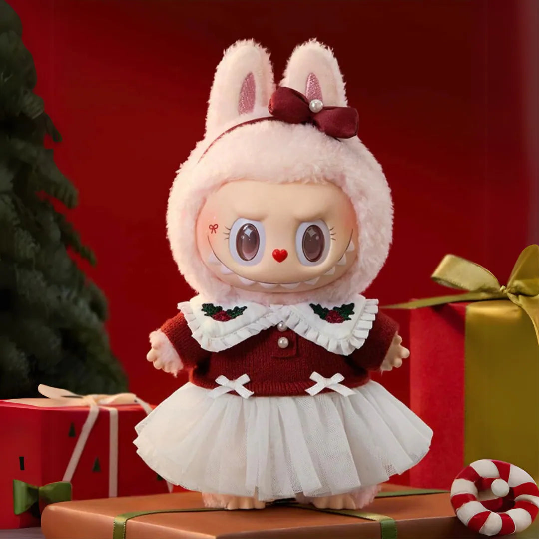 Plush toy with bunny ears and red sweater in front of Christmas presents and candy cane