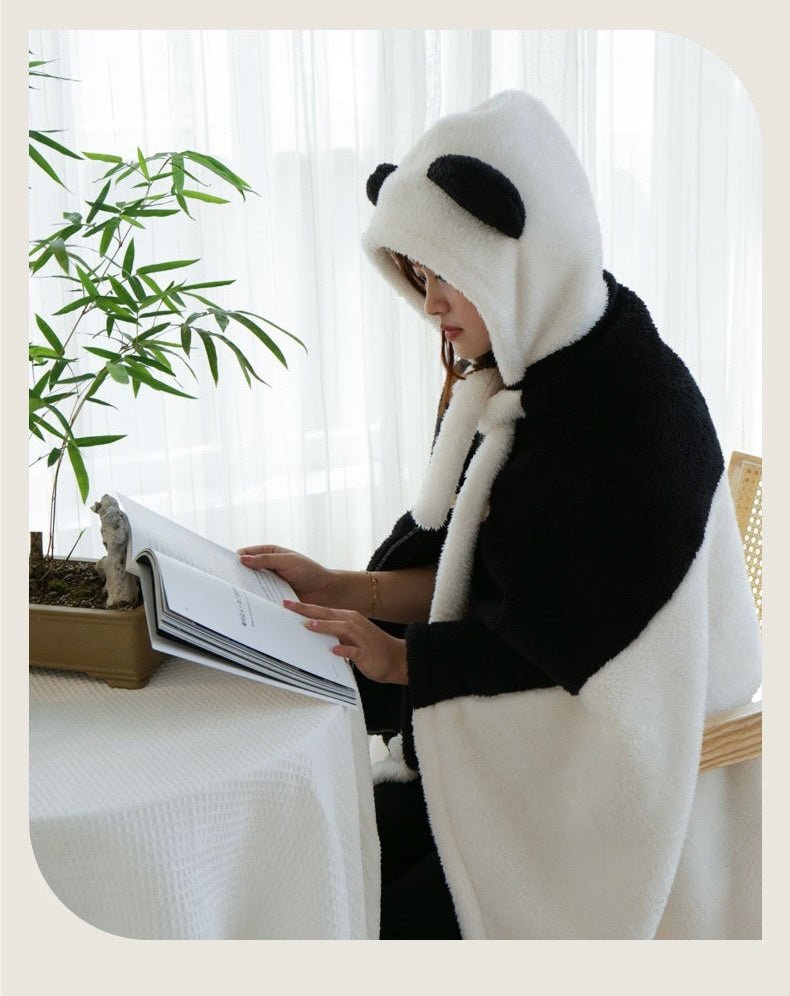 Person wearing a panda costume reading a book indoors.