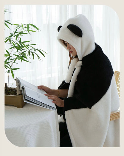 Person wearing a panda costume reading a book indoors.