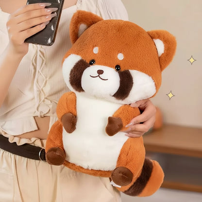 Person holding a plush red panda toy with a blurred background