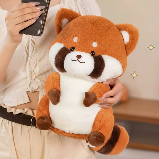 Person holding a plush red panda toy with a blurred background