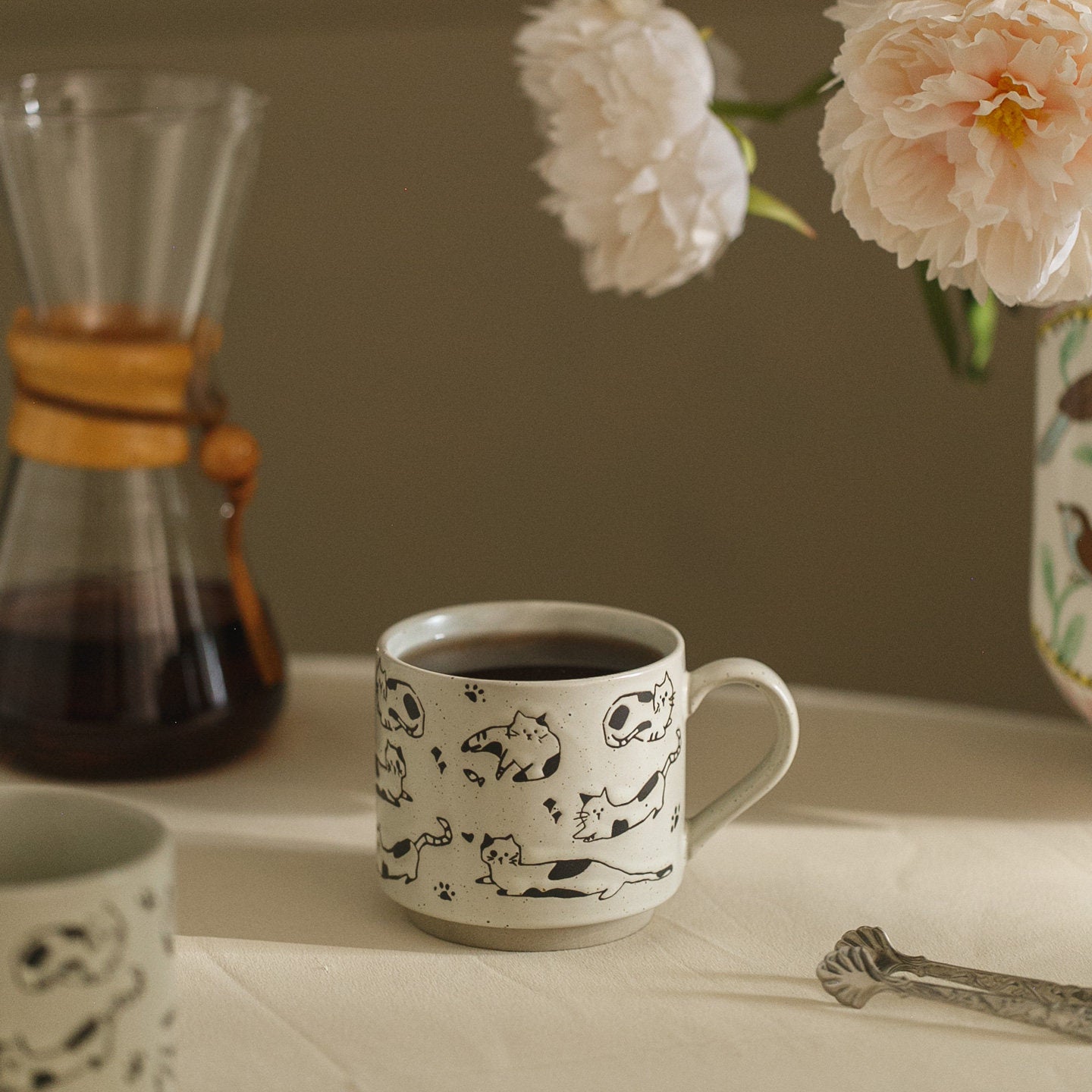 Ceramic mug with animal prints on a table with coffee and flowers
