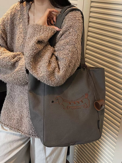 Black embroidered dachshund tote bag worn over the shoulder