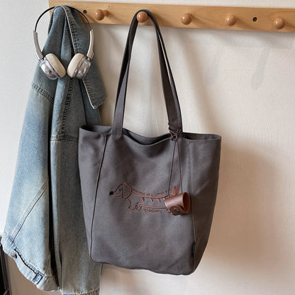 Black embroidered dachshund tote bag hanging on wall hook