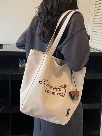 Khaki embroidered dachshund tote bag worn over the shoulder