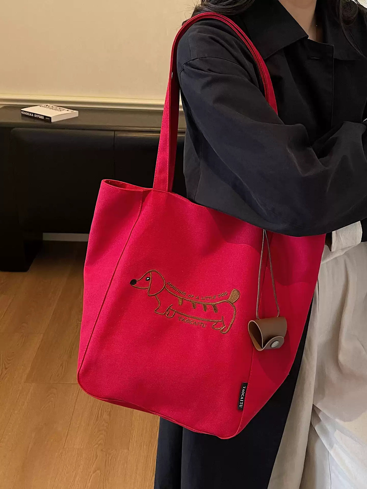 Red embroidered dachshund tote bag worn over the shoulder