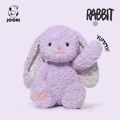 Purple plush rabbit toy with a floral bag on a white background, featuring the brand 'Jooki'.